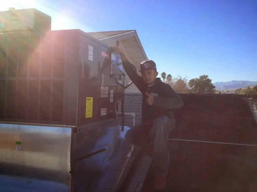 HVAC technician performing HVAC Inspection on a rooftop unit in Bainbridge Island